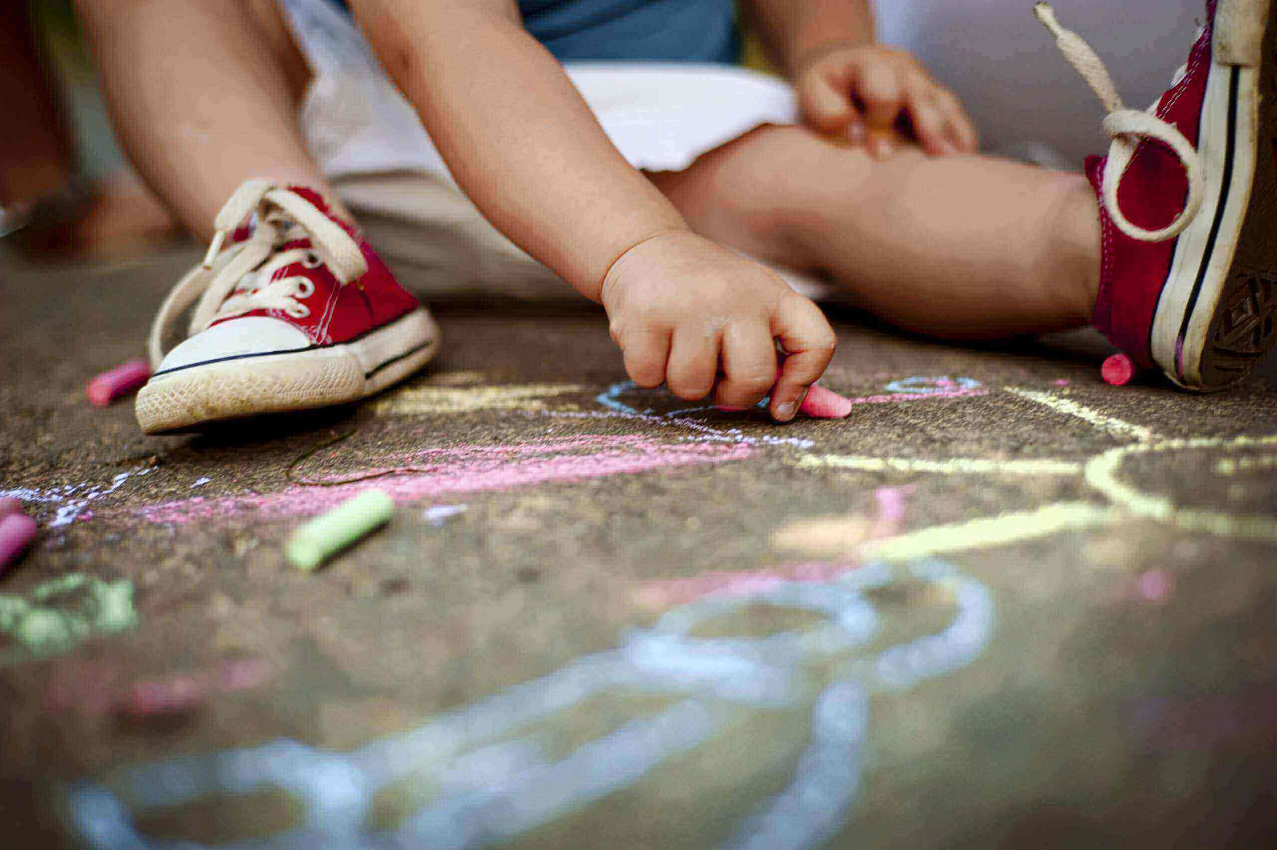 Close up of boy drawing with chalks